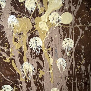 May include: Abstract art painting with brown, beige, and white paint splatters. The paint is applied in a random pattern, creating a dynamic and textured surface.