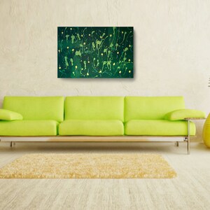 May include: Abstract painting with a dark green background and yellow splatter paint. The painting is framed and hanging on a wall above a lime green sofa.