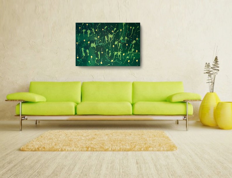 May include: Abstract painting with a dark green background and yellow splatter paint. The painting is framed and hanging on a wall above a lime green sofa.