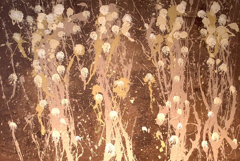 May include: Abstract painting with a brown background and white and gold splatters of paint. The splatters are arranged in a pattern that resembles flowers or trees.