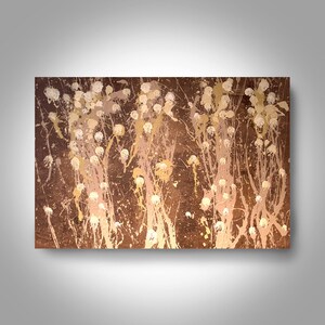 May include: Abstract painting with a brown background and white and gold splatters. The splatters are arranged in a pattern that resembles a forest of trees.