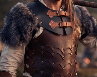 May include: A brown and black leather chest armor with fur shoulder pads. The armor has decorative rivets and two leather straps with buckles. The person is holding a wooden axe.