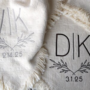 Peut inclure: Deux couvertures blanches avec des initiales et des dates brod&eacute;es. La premi&egrave;re couverture a les initiales "VIK" et la date "2.14.25". La deuxi&egrave;me couverture a les initiales "D|K" et la date "3.1.25".