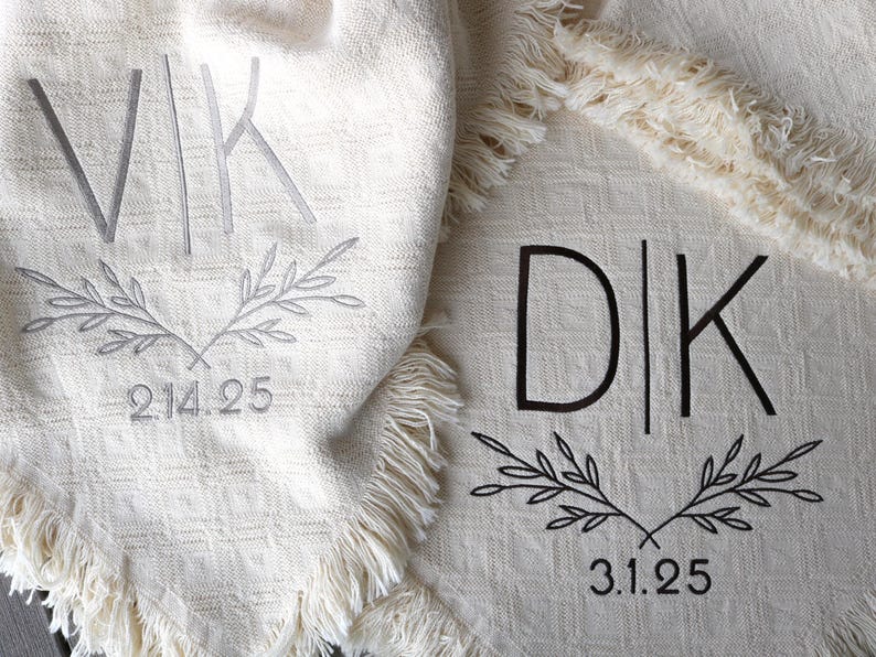 Peut inclure: Deux couvertures blanches avec des initiales et des dates brod&eacute;es. La premi&egrave;re couverture a les initiales "VIK" et la date "2.14.25". La deuxi&egrave;me couverture a les initiales "D|K" et la date "3.1.25".