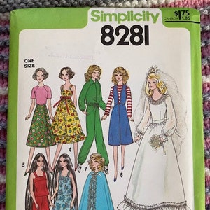 May include: Simplicity sewing pattern number 8281 for making doll clothes. The pattern includes instructions for making a variety of outfits, including a wedding dress, a cape, a dress with a skirt, a jumpsuit, and a skirt and top.