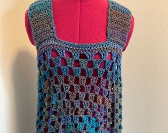 May include: A sleeveless crochet top with a square neckline and a geometric pattern in shades of blue, green, and brown.