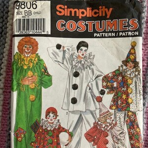 May include: A Simplicity Costumes sewing pattern envelope, number 9806, for child sizes BB (2-12). The front features illustrations of five different clown costumes, including green, white, red, and multi-colored star-patterned designs with ruffles.