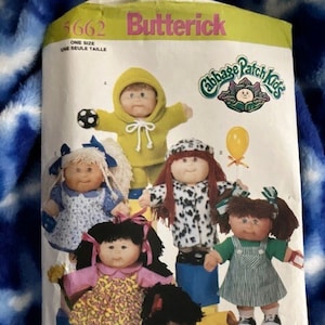 May include: A Butterick sewing pattern featuring several Cabbage Patch Kids dolls. The dolls are dressed in various outfits, including a yellow hooded sweatshirt, a dress with a floral pattern, and a green overall dress. The pattern includes the Cabbage Patch Kids logo.