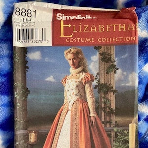 May include: A sewing pattern for a red and white Elizabethan costume. The pattern is from the Simplicit Elizabetha Costume Collection and is size HH. The pattern shows a woman wearing a red and white dress with a white lace collar.