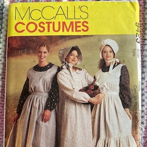 May include: A McCall's Costumes pattern cover featuring three women in historical dresses and bonnets. The cover is yellow with the text "McCall's Costumes" in large orange letters. The women are wearing long dresses and aprons.