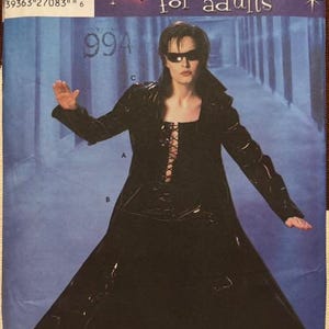 May include: Simplicity costume pattern for adults. The pattern features a black vinyl-like coat with a lace-up bodice and a long skirt. The model is wearing sunglasses. The pattern includes sizes 14-22.