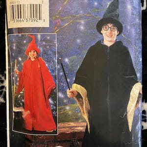 May include: A vintage sewing pattern for a wizard costume. The pattern is for sizes 12, 14, and 16. The pattern includes instructions for making a long, black robe with a gold trim and a pointed hat. The pattern also includes instructions for making a red robe with a pointed hat.