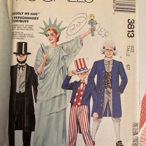 May include: McCall's costume pattern featuring illustrations of historical figures, including the Statue of Liberty, Uncle Sam, and a colonial gentleman. The pattern includes sizes 6/7 and the text "Proudly We Hail".