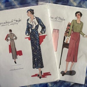May include: Two vintage sewing pattern packets featuring illustrations of 1930s fashion designs. The packets, labeled "Decades of Style Pattern Company," showcase drawings of dresses and separates in various colors, including blue, red, and green. The packets are sealed in clear plastic.