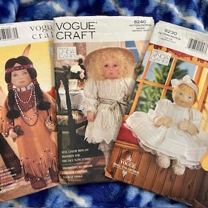 May include: Three vintage Vogue Craft doll sewing patterns featuring a Native American doll, a girl in a white dress, and a girl in a white dress with a bonnet. The patterns are titled "Vogue Doll Collection" and include instructions for making the dolls.