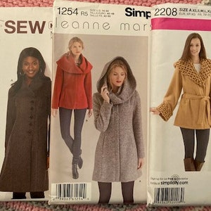 May include: Three sewing patterns for coats. The first pattern is for a brown coat with a mandarin collar, the second pattern is for a red coat with a cowl neck, and the third pattern is for a tan coat with a shawl collar.