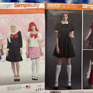 May include: Two Simplicity sewing pattern envelopes, 8160 and S9006, displaying various costume designs. The left envelope shows three outfits with pleated skirts and bows. The right envelope features a black dress, a purple dress, and a red hooded cape.