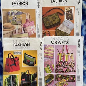 May include: Four McCall's sewing pattern envelopes for fashion accessories and crafts. The patterns feature designs for handbags, totes, and other accessories. The envelopes display colorful illustrations of the finished products, with text including pattern numbers and the brand name.