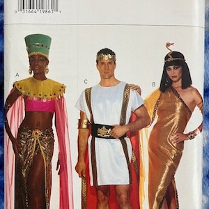 May include: A sewing pattern for three costumes: a gold and red Egyptian-style dress, a white tunic with a red cape and gold belt, and a pink and gold Egyptian-style dress with a green headpiece. The pattern is called Butterick 3587.