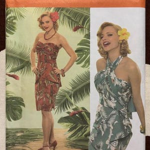 May include: Simplicity sewing pattern 4559 featuring two vintage-style dresses. One dress is a strapless, knee-length design with a red and brown pattern. The other is a halter-neck dress with a green and white floral print. The pattern includes size information.