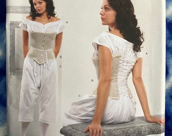 May include: A sewing pattern for a white corset with a lace-up back. The pattern is from Simplicity and is designed by Kay. The pattern number is 2890 and the sizes are US 16, 18, 20, 22, 24, EUR 42-50, FR 44-52.