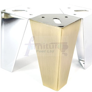May include: Two metal furniture legs, one in silver and one in gold. The legs are tapered and have a square base.