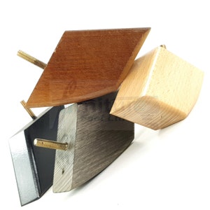 May include: Three wooden furniture legs in different colors and styles. One is a dark brown diamond shape, one is a light brown square shape, and one is a black and gray rectangular shape.
