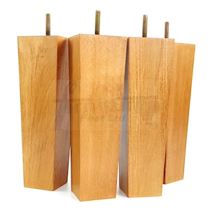 May include: Four wooden furniture legs with a light brown finish and a metal screw at the top of each leg.