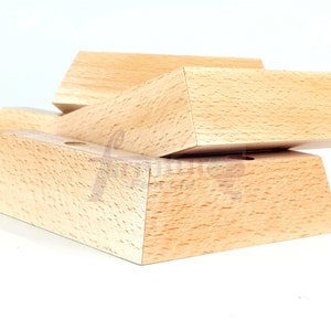 May include: A set of two wooden display stands, one stacked on top of the other. The stands are made of light brown wood and have a smooth, polished finish.