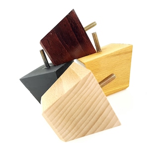 Puede incluir: Tres patas de muebles de madera en diferentes colores: marrón oscuro, marrón claro y negro. Cada pata tiene una base cuadrada y una parte superior triangular con un tornillo.