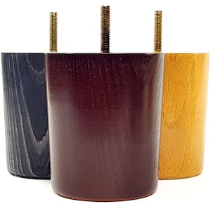 May include: Three wooden furniture legs in different colors: black, brown, and natural wood. Each leg has a threaded metal screw for attaching to furniture.