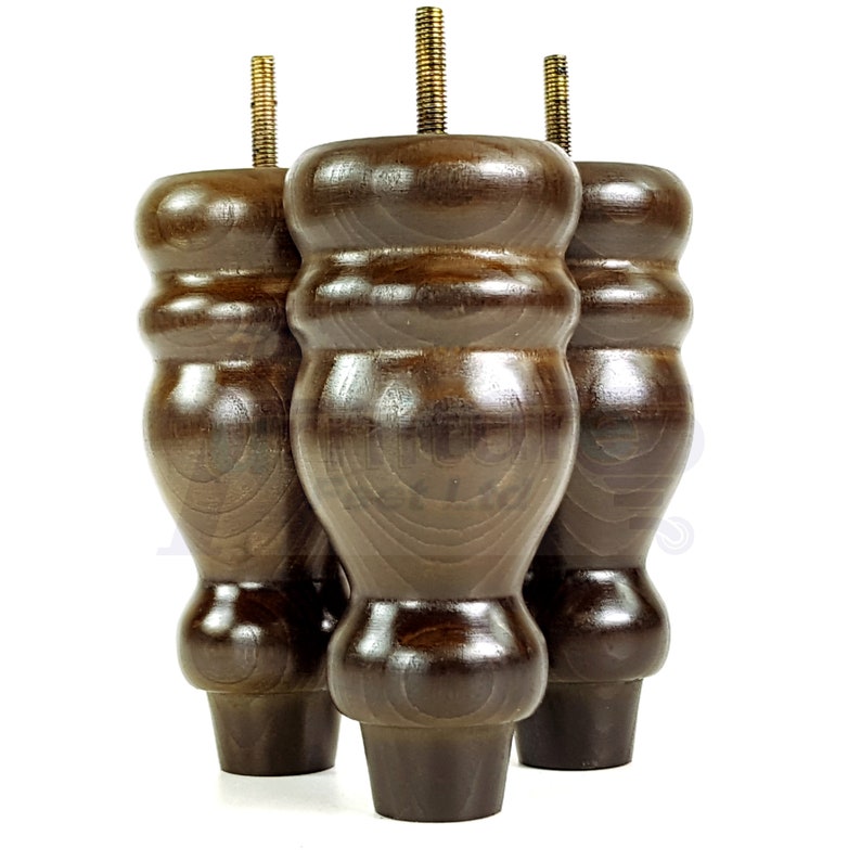 May include: Three dark brown wooden furniture legs with a threaded metal insert at the top. The legs have a bulbous, rounded shape.