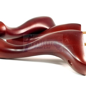 Może przedstawiać: Trzy drewniane nóżki do mebli z ciemnobrązowym wykończeniem. Każda nóżka ma zakrzywiony kształt i gwintowany metalowy wkład do mocowania do mebli.