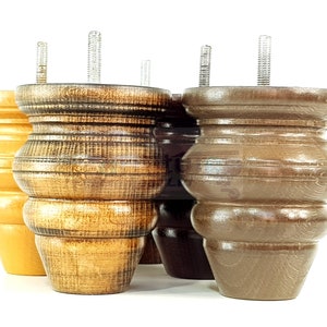 May include: Four wooden furniture legs with a turned design. Two legs are a light brown color and two legs are a dark brown color.