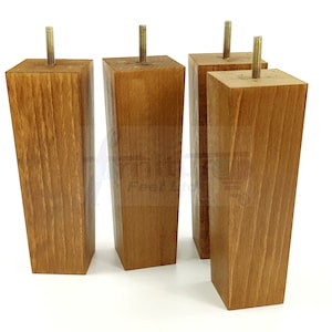 May include: Four wooden furniture legs with a brown stain finish. Each leg has a metal screw at the top.