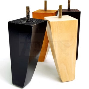 Puede incluir: Cuatro patas de muebles de madera en diferentes colores: negro, marrón claro y madera natural. Las patas son cónicas y tienen una base cuadrada.