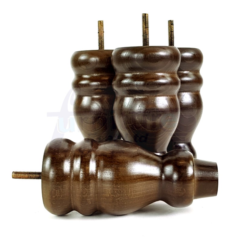 May include: Four dark brown wooden furniture legs with a decorative, rounded design. Each leg has a threaded metal screw at the top.