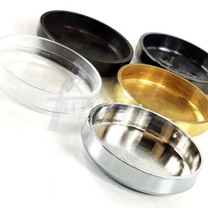 May include: Four different round furniture leg caps. The caps are made of clear plastic, black plastic, brass, and chrome.