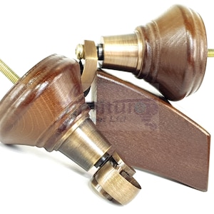 May include: Two wooden furniture legs with brass accents and threaded bolts. The legs are a dark brown color and have a turned design. The brass hardware includes a bracket and a caster wheel.