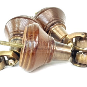 May include: Three brown wooden furniture casters with brass wheels. The casters have a threaded screw for attaching to furniture.