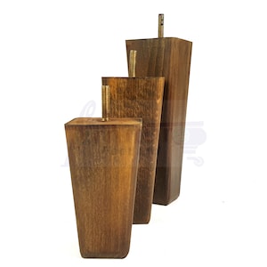 May include: Three wooden furniture legs in different sizes. The legs are tapered and have a dark brown stain. Each leg has a brass threaded insert for attaching to furniture.