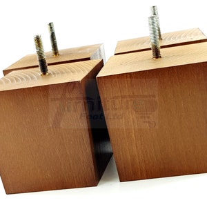 May include: Four wooden furniture legs with a brown stain finish. Each leg has a metal screw threaded through the top.