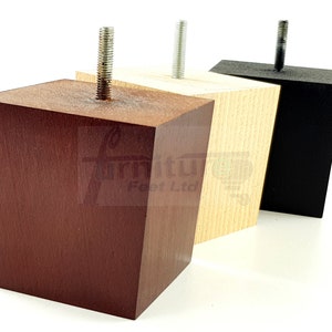 Op de afbeelding: Drie houten meubelpoten in verschillende kleuren: donkerbruin, natuurlijk hout en zwart. Elke poot heeft een kubusvorm met een metalen schroef die uit de bovenkant steekt. De poten zijn ontworpen voor meubelondersteuning.