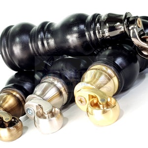 May include: Three wooden furniture casters with different finishes. One caster is black with a silver wheel, one is silver with a silver wheel, and one is gold with a gold wheel.