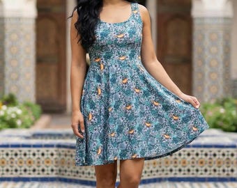 Puede incluir: Un vestido sin mangas de color verde azulado con un estampado floral. El vestido tiene un escote redondo y una falda acampanada. El vestido se lleva con zapatillas blancas. Una pegatina "Made in USA" es visible en la esquina inferior derecha.