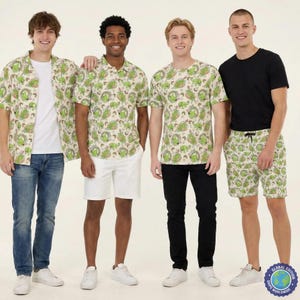 Könnte beinhalten: Eine Bekleidungskollektion mit einem sich wiederholenden grünen Dinosaurier-Muster. Das Set umfasst ein kurzärmeliges Hemd, ein Poloshirt, ein T-Shirt mit Rundhalsausschnitt und eine Shorts mit Kordelzug, alle mit demselben verspielten Druck.