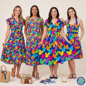 May include: Four dresses featuring a vibrant, multicoloured Mickey Mouse head pattern on a dark blue background. The styles include a flutter-sleeve tiered dress, a sleeveless shift dress, a wrap-style dress, and a halter-neck dress with a full skirt.