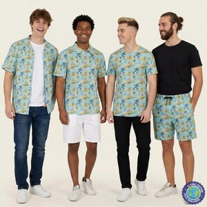 Może przedstawiać: Jasnoniebieska koszula z krótkim rękawem, jasnoniebieska koszulka polo, jasnoniebieski t-shirt i jasnoniebieskie szorty, wszystkie z powtarzającym się wzorem postaci z kreskówek w kolorze żółtym, niebieskim i zielonym, noszone z dżinsami, białymi szortami i czarnymi spodniami.