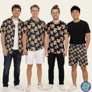 May include: Four people modelling different outfits. Two are wearing short-sleeved button-down shirts with a black background and a colourful cartoon character pattern. One is wearing a black t-shirt and black shorts with the same pattern. The last person is wearing a black t-shirt and black trousers.