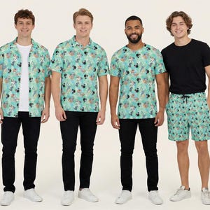 May include: A collection of apparel featuring a light green fabric with a repeating pattern of Disney characters. The set includes a short-sleeved button-down shirt, a polo shirt, a crew-neck t-shirt, and shorts, all paired with solid black trousers.